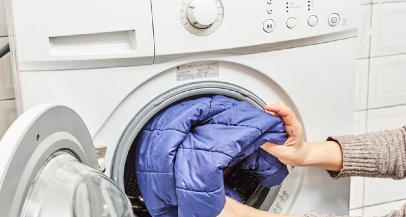 Warum legen manche Hausfrauen beim Waschen einer Daunenjacke ein Handtuch in die Waschmaschine?